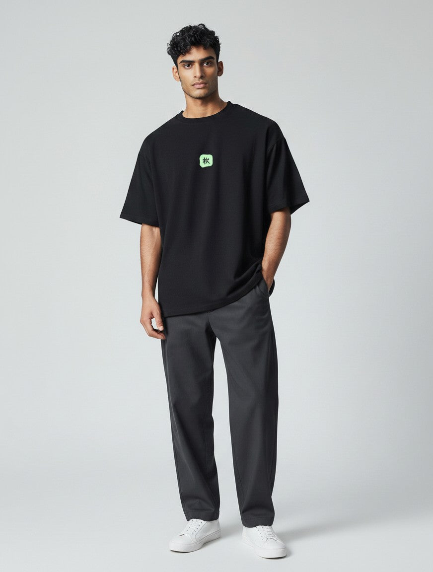 Born West black oversized terry-knit tee with a small green square graphic on the chest.