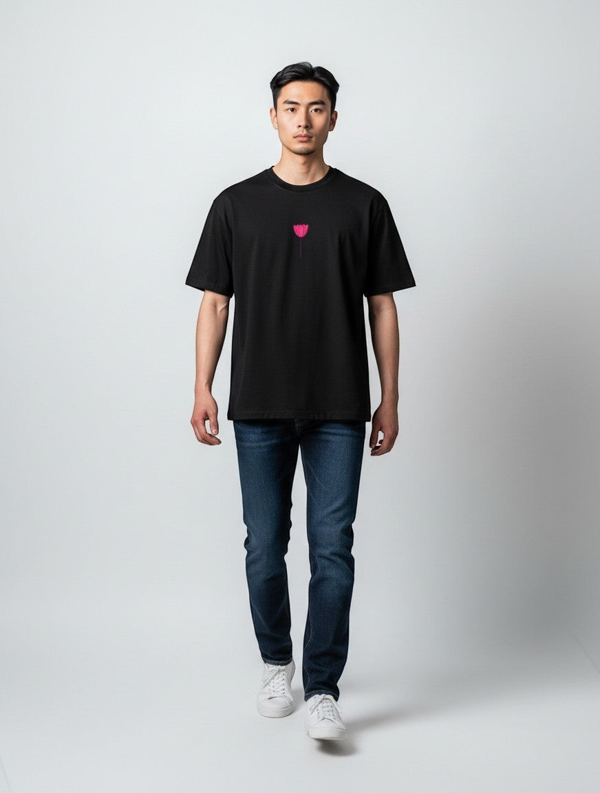 Born West black oversized terry tee with a small pink embroidered tulip graphic on the chest.