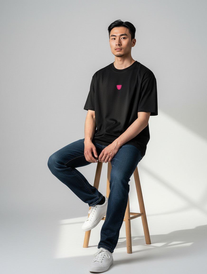 Born West black oversized terry tee with a small pink embroidered tulip graphic on the chest.